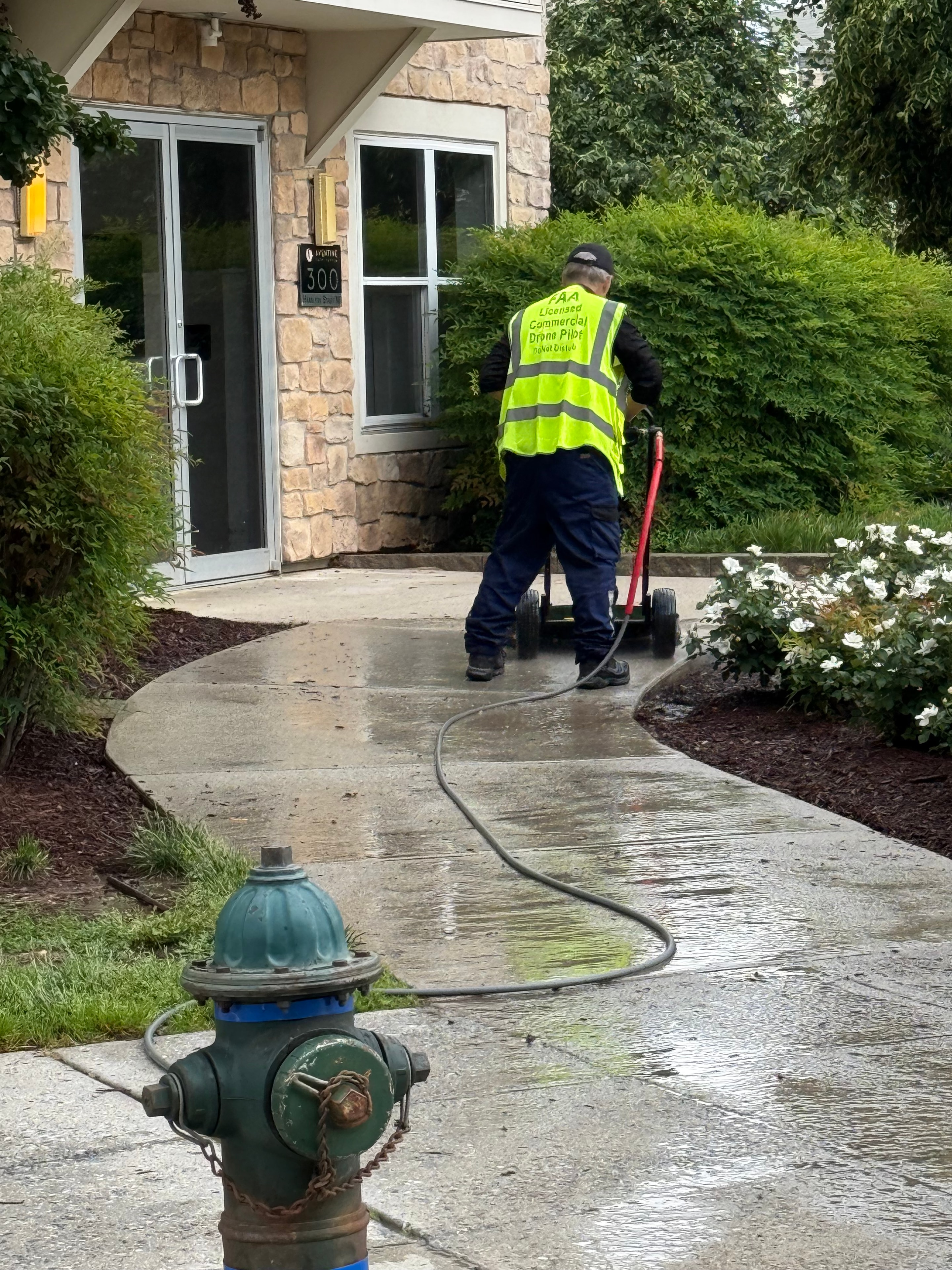 Worker pressure washing residential driveway